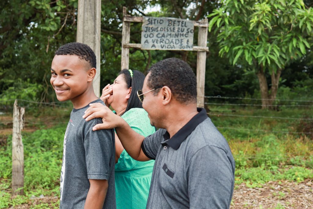 Marcelo smiling at camera with parents